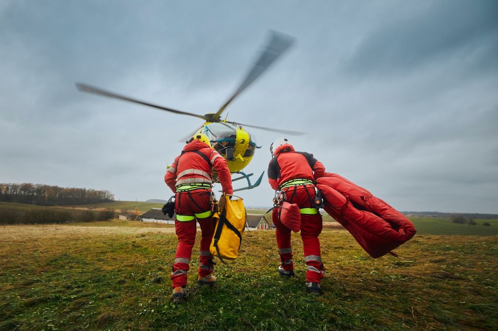 Two paramedic with safety harness runnig to helicopter emergency medical service